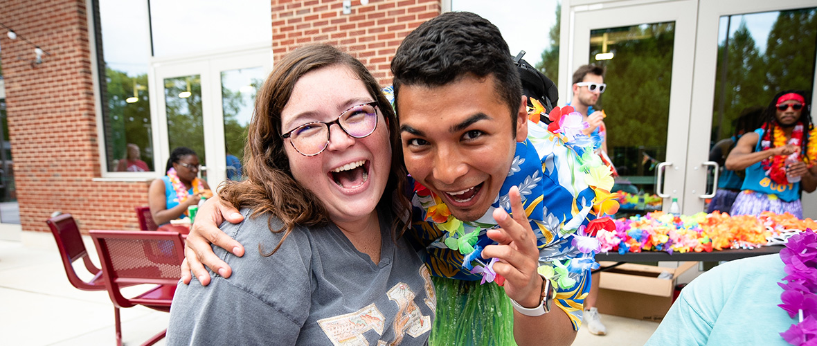 students hugging at Totally Tiki Luau event at Rec Center