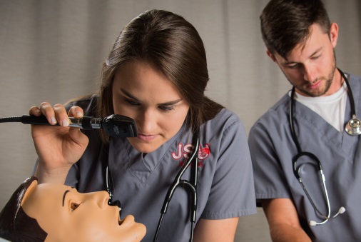 Nursing student examines simulation mannequin