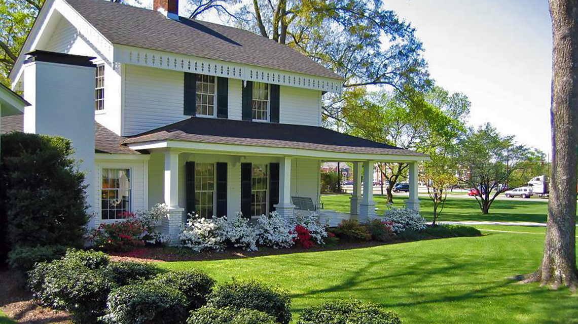 Side view of the alumni house with azaleas