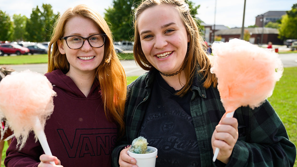 Two students enjoy cotton candy and snow cones at the Homecoming Carnival