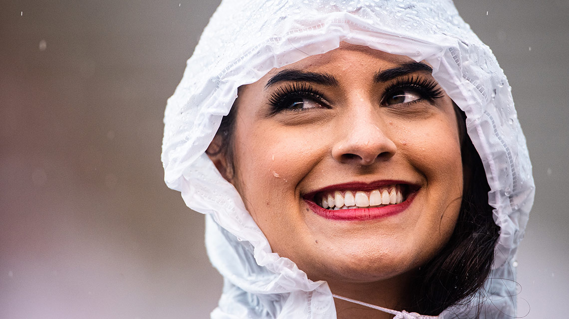 A ballerina wears a rain poncho and a huge smile during Homecoming pre-game  festivities