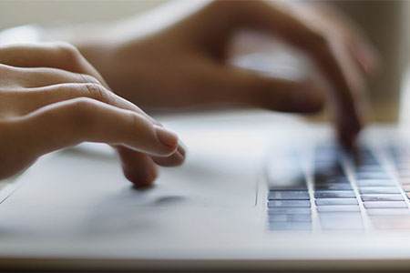 Close up of hands on laptop