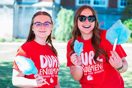 Two students enjoying cotton candy at Dual Enrollment Orientation