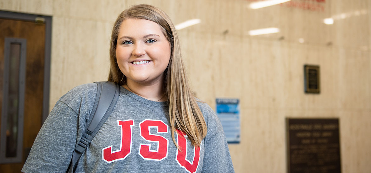 Student in the library with JSU t-shirt on