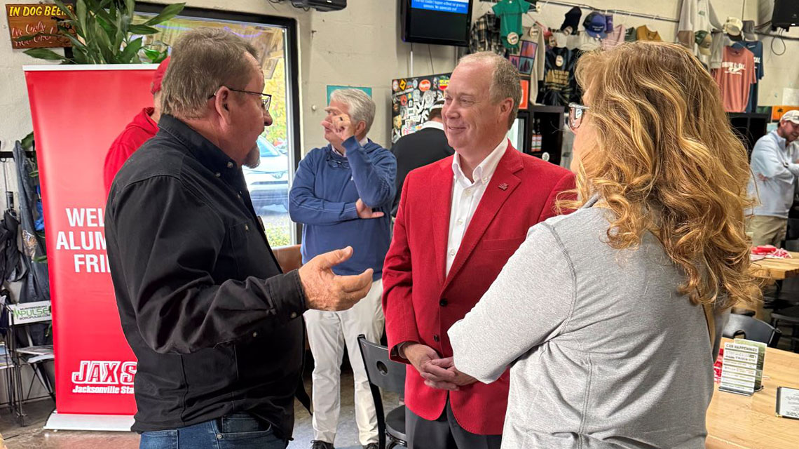 The president speaks with alumni