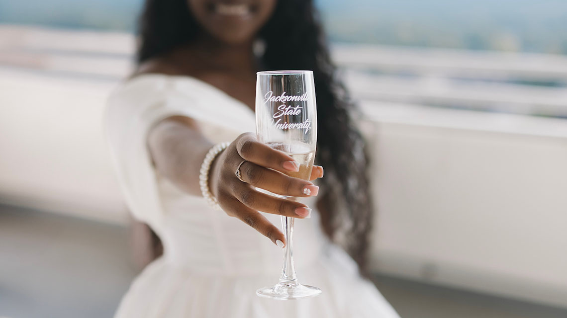 A student proudly shows off her champagne glass for the toast