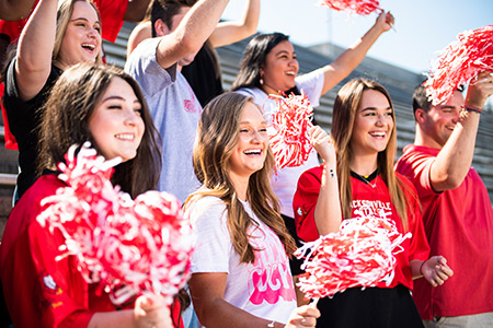 JSU students, pom poms in hands, cheering at a Gamecocks football game