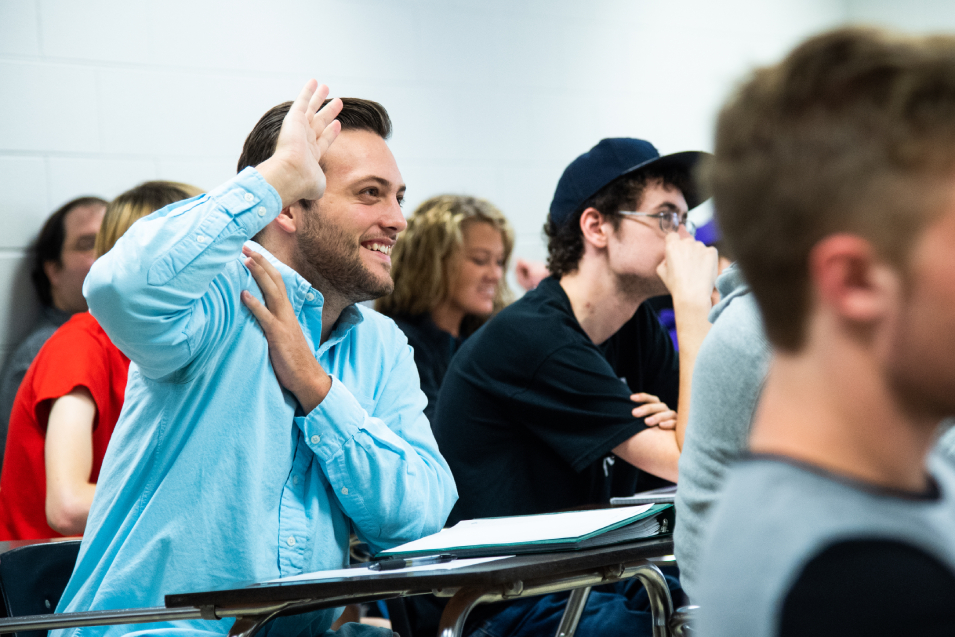 Student raising hand in classroom