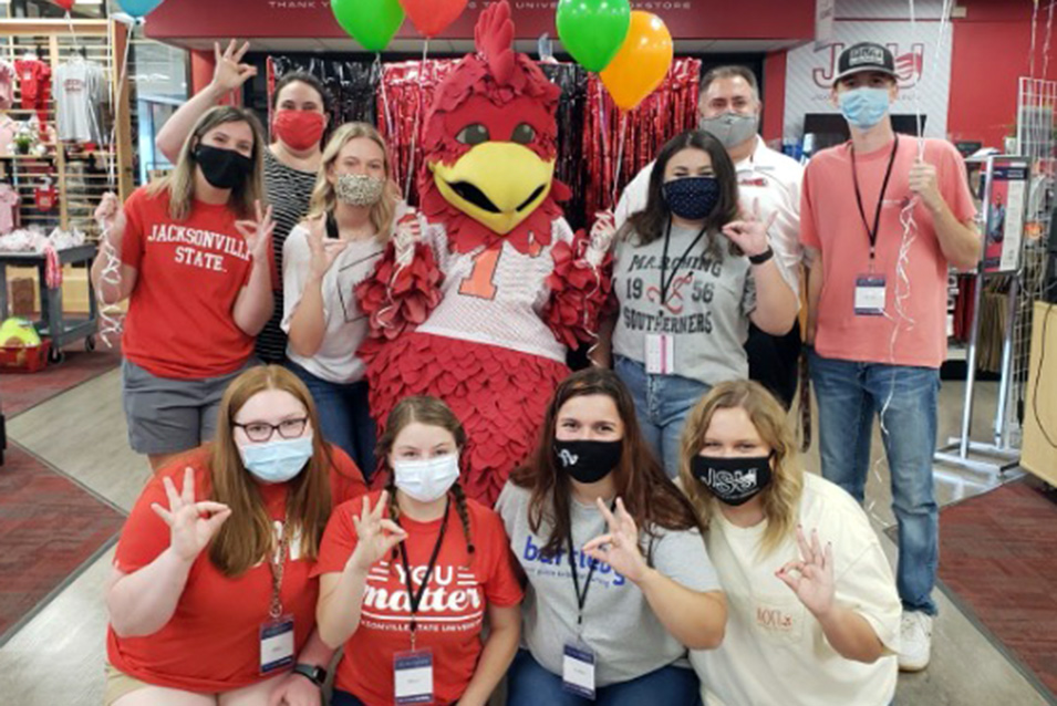 Student employees pose with Cocky and balloons inside the JSU Campus Bookstore
