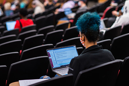 A student takes notes on her laptop during a class in Merrill Hall