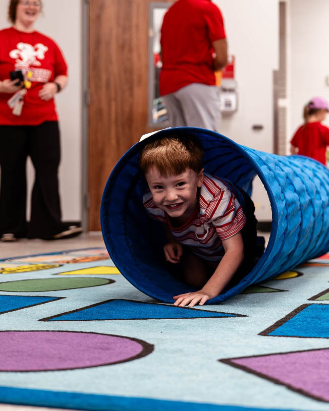 Young child crawling out of a play tube