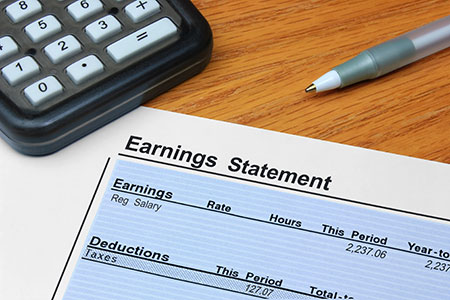An earnings statement and a calculator