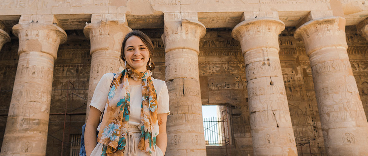 Young Caucasian woman walking in the ancient Egyptian temple in Luxor