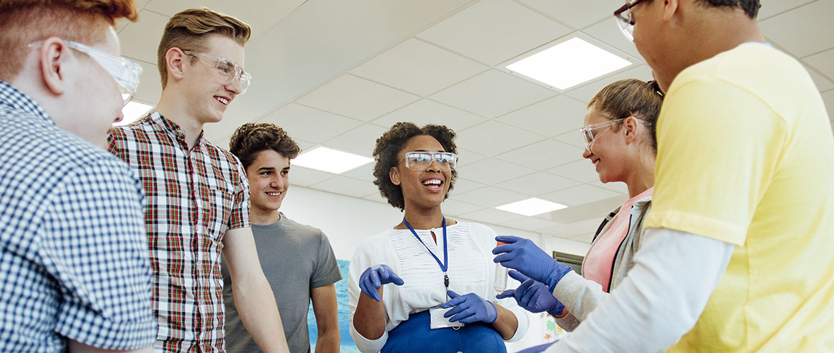 Science teacher working with students in a lab