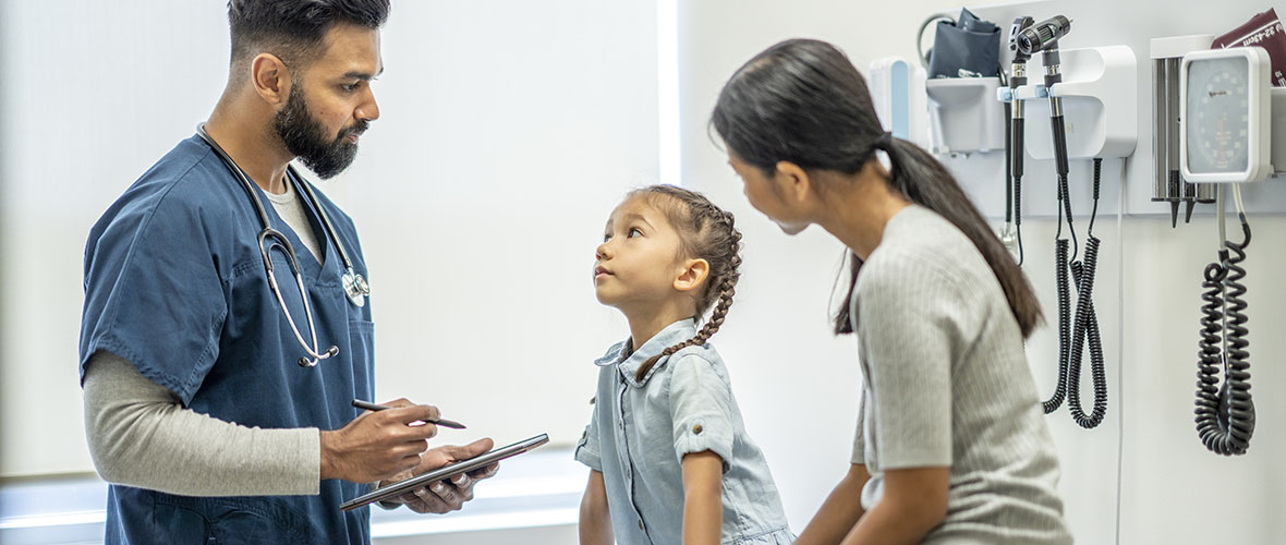 Male nurse speaks with mother and young child