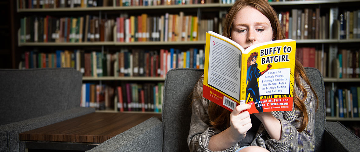 Student reading book in library