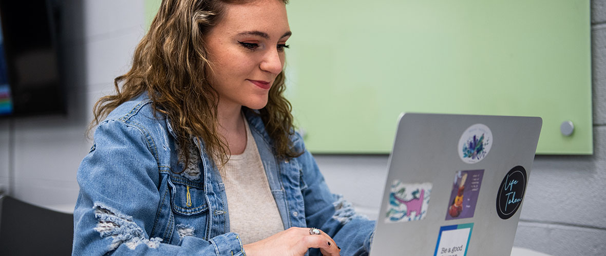 Student typing on laptop computer