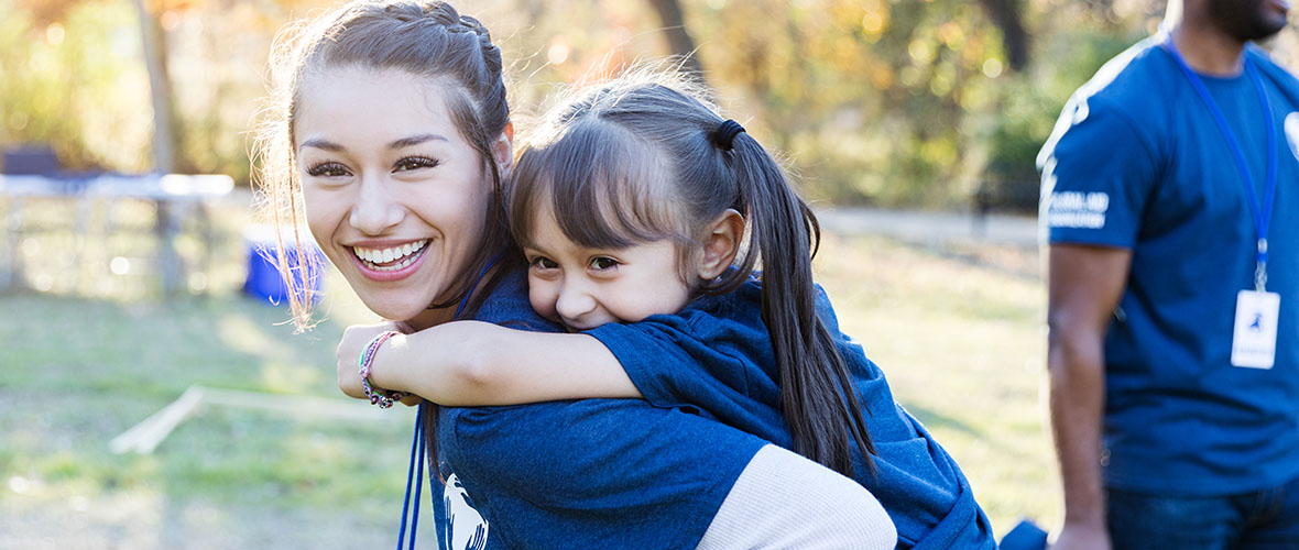 A teacher gives a youngster a piggy back ride