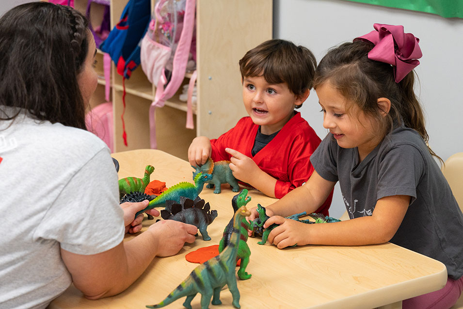 A pre-k teacher handles manipulatives with her children