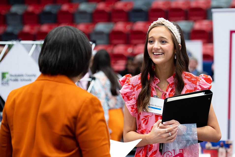 A prospective student talks with a prospective employer