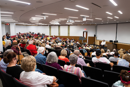 Photograph of a packed auditorium in Merrill Hall. 