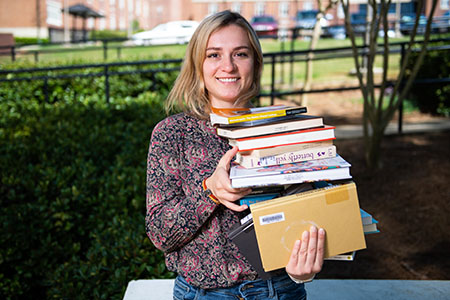 Student holding stack of books