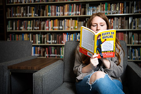 Student sits while reading a book