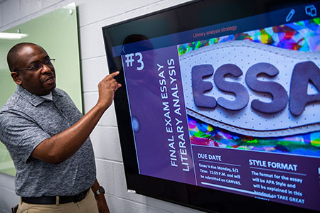Rodney Bailey points to screen while teaching