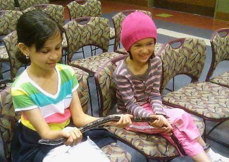 Young participants holding a snake at a Canyon Center event
