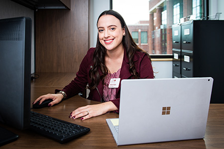 A student sitting at her computer during her work hours as a work-study program participant