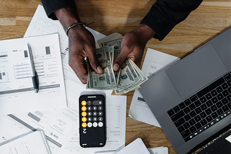 A student using a calculator to add up her cost of attendance