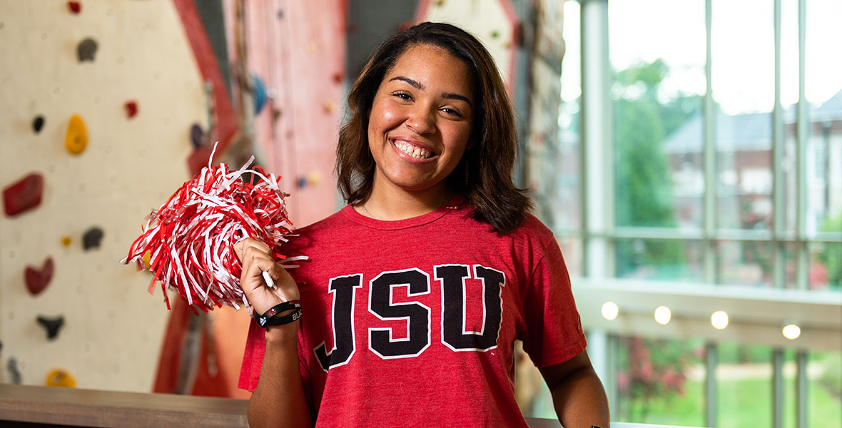 Student at UREC shaking a pom pom