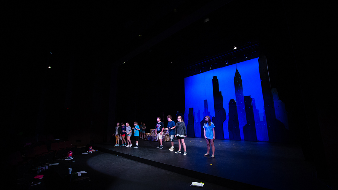 students on stage in stone center's main theatre