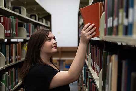 student holding a stack of books