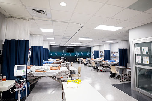 Nursing student examines simulation mannequin