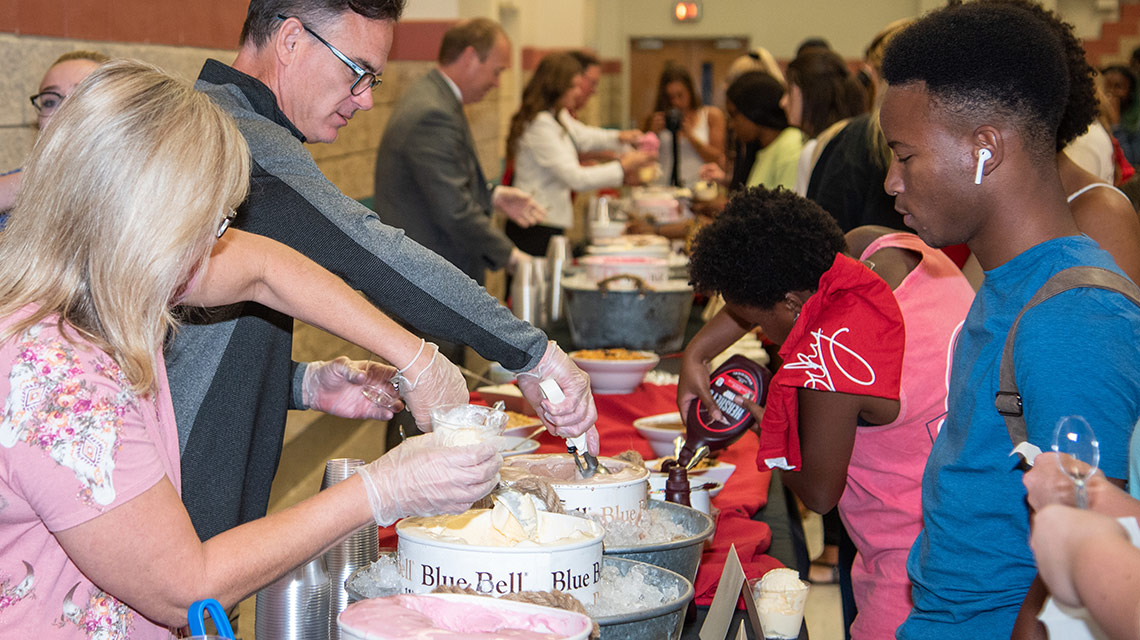 Administration serving ice cream to students at ice cream social
