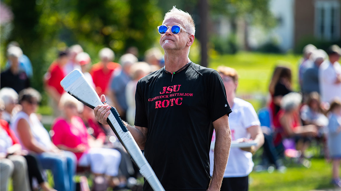 A JSU color guard alumnus spins his rifle in the homecoming parade