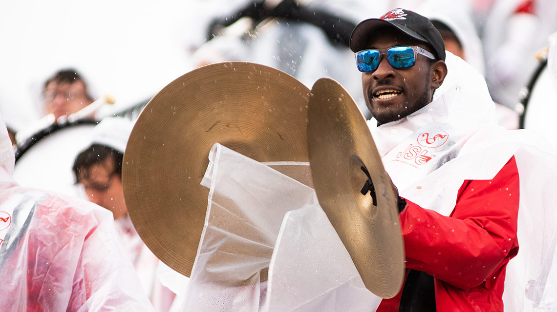 A cymbal player for the Southerners plays on in the rain