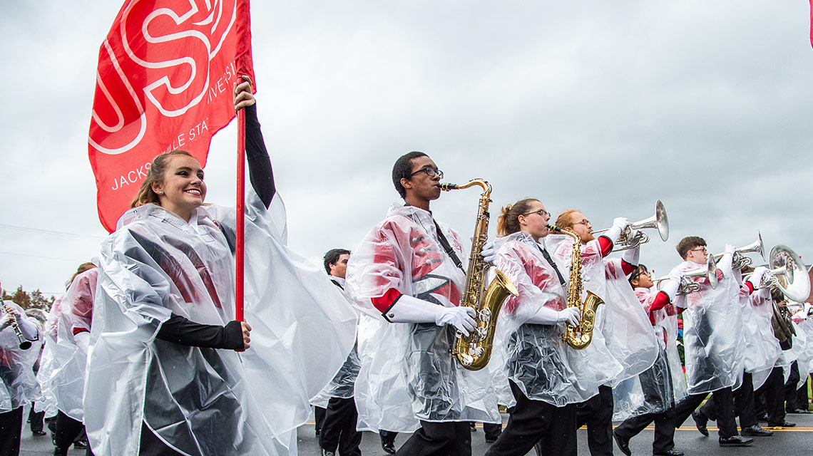 The Marching Southerners, all  in ponchos, march in the parade
