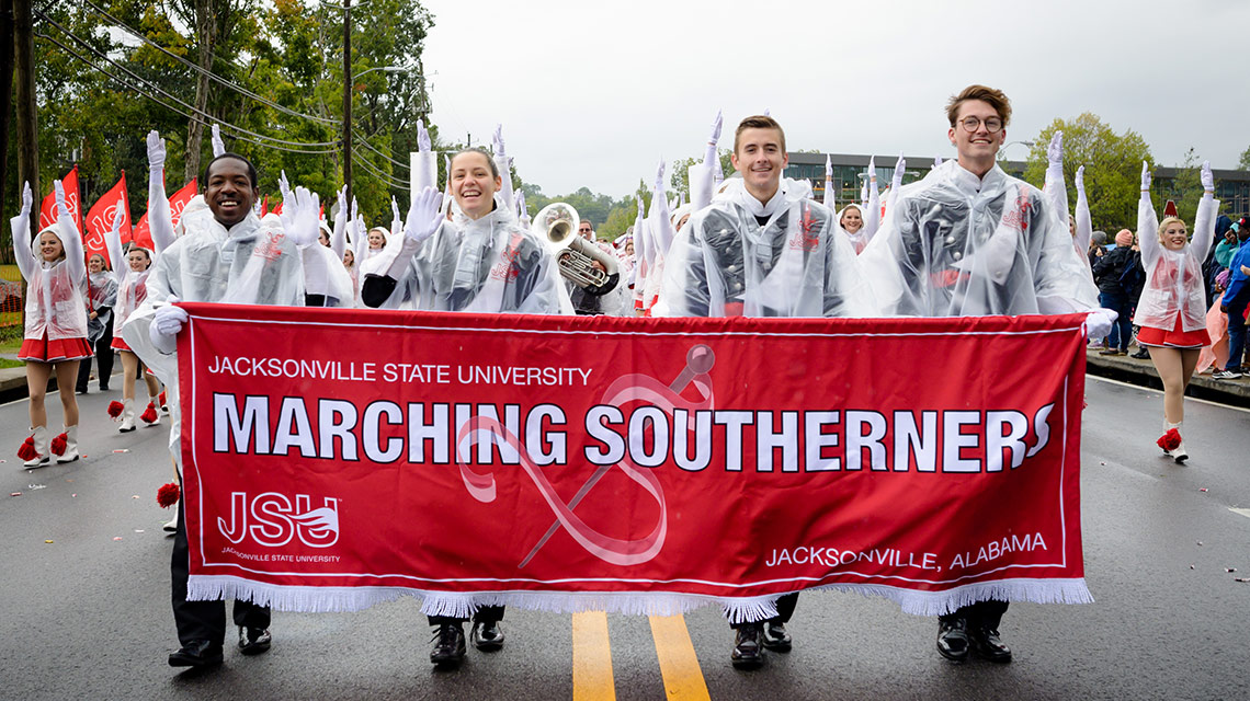 The Southerners drum majors lead the band with their banner