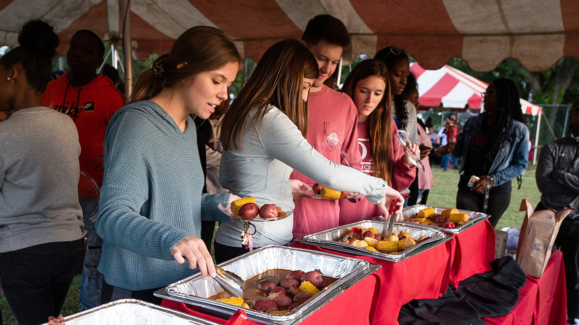 Students scoop up shrimp, potatoes, and corn at the shrimp boil