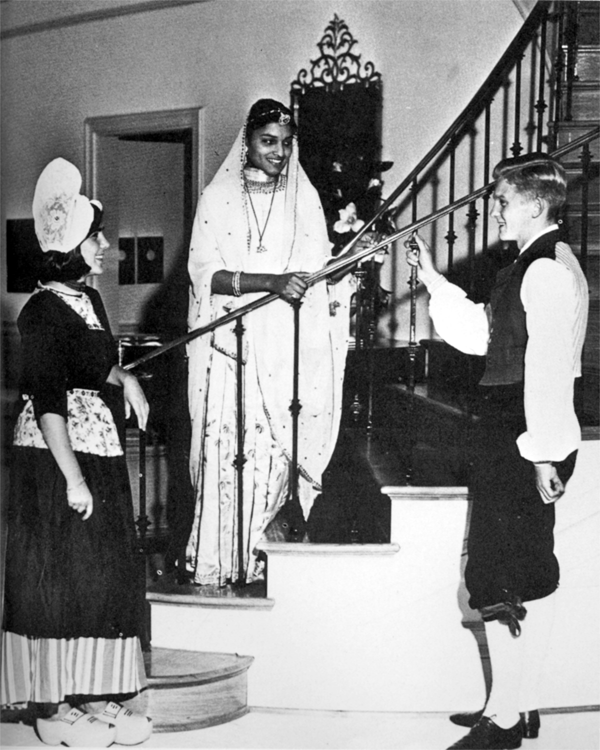 international students in native dress, standing at stairs in International House