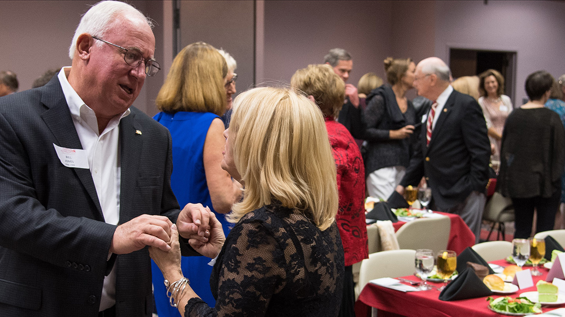 Attendees visit at a past IH Reunion