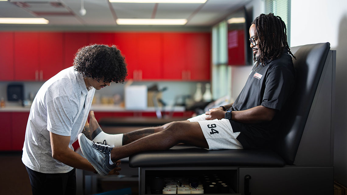 A student in the MAT program having his leg examined