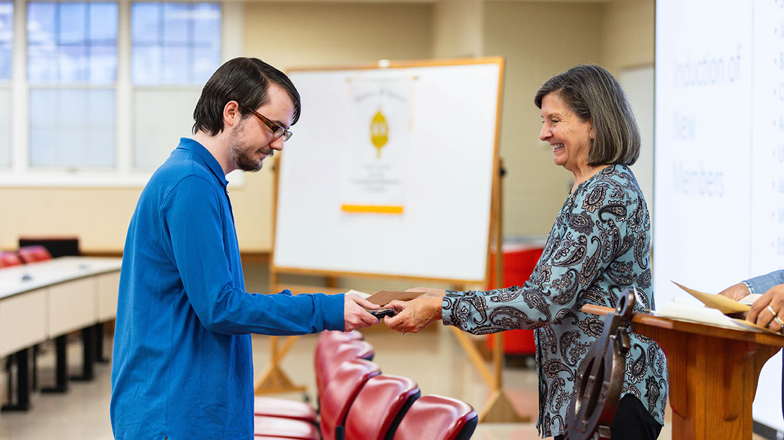 Student receiving his certificate from Dr Case