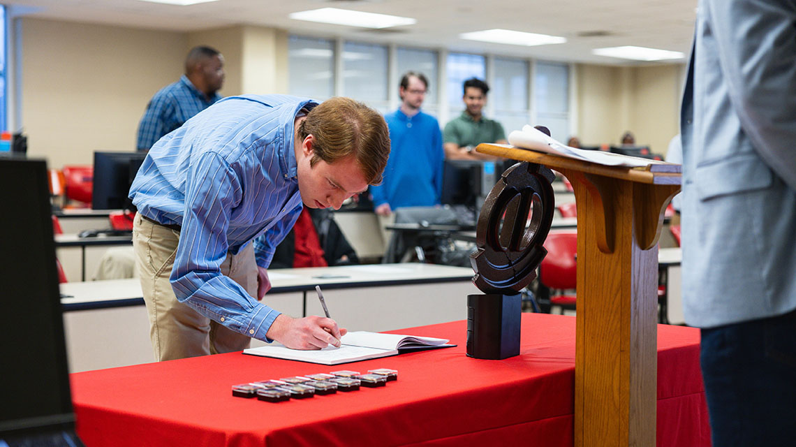 A student signs the roll