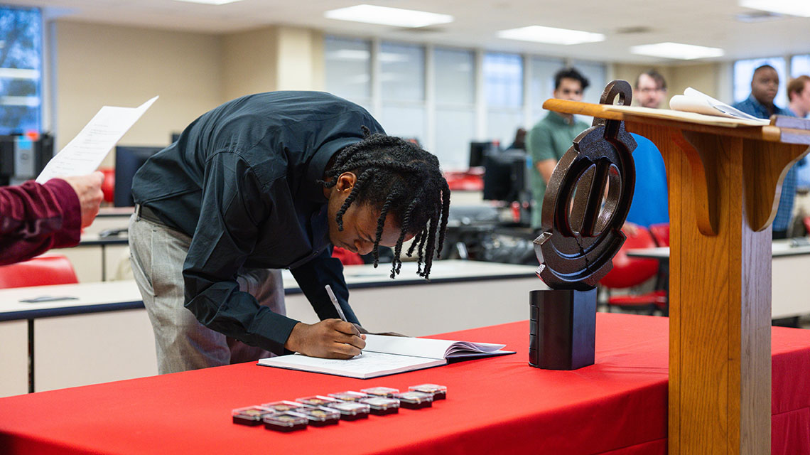 A student signs the roll