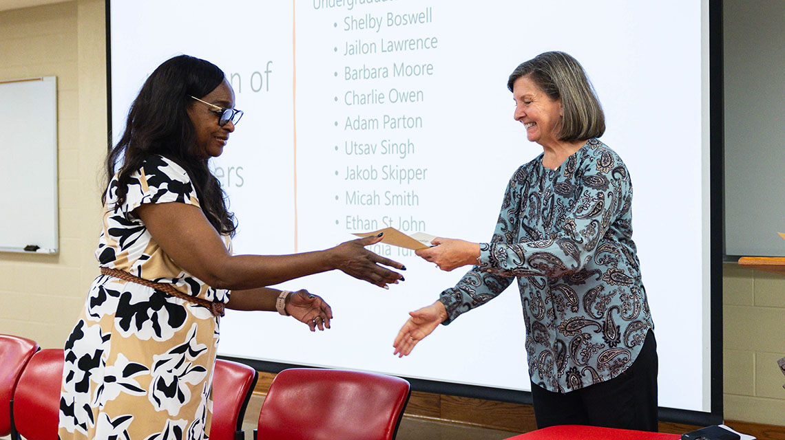 A student receives her certificate from Dr Case