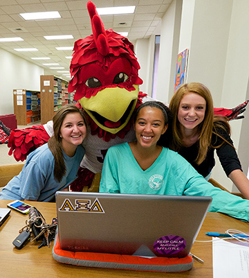 JSU Mascot Cocky with students at the library