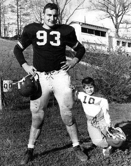 Donald “Dee” Salls as a child, on Burgess-Snow Field, in front of the old press box, next to one of his dad's players.